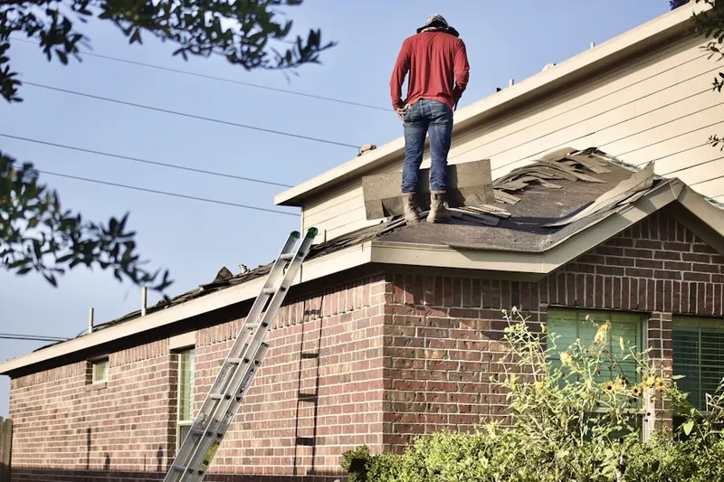 Professional roofer working on a residential roof in Ryot